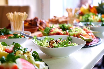 Salads and vegetables spread out on a dining table