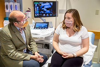 A BIDMC OB/GYN is talking with a patient during an ultrasound appointment.