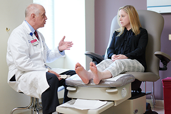 John Giurini, DPM of BIDMC talks to a patient about her foot problems.