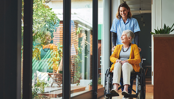 Nurse pushing woman in wheelchair