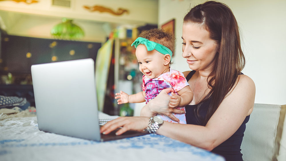 New mother with baby joining parent support group online