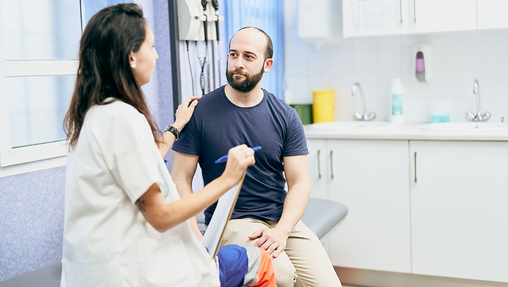 Female doctor speaking to male patient