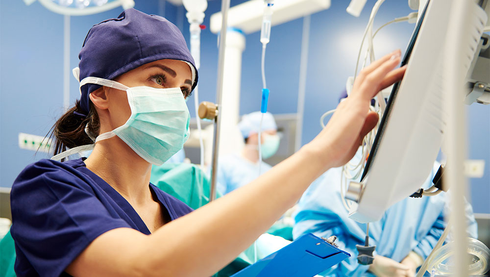 Nurse looks at a monitor in a hospital room