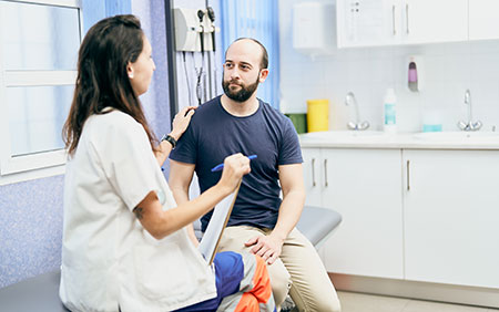 Female doctor speaking to male patient