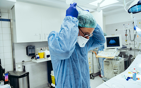 ICU Staff Member Puts on Protective Gear Before a Procedure ICU Staff Member Puts on Protective Gear Before a Procedure