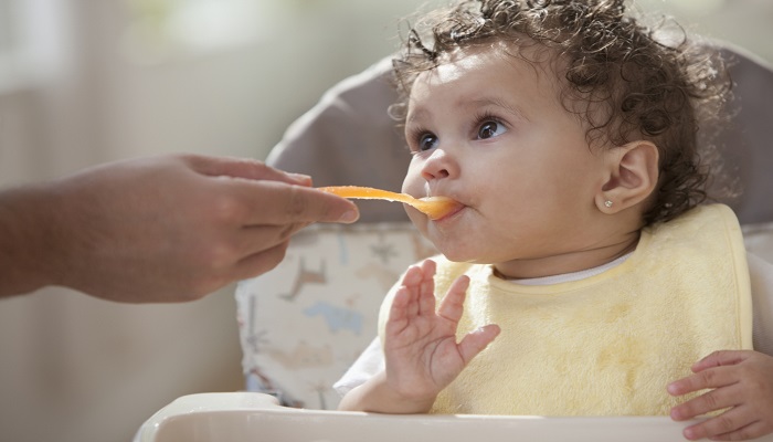Baby girl tries first solid foods