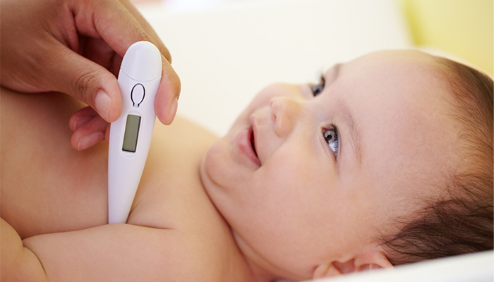 Baby having temperature checked with thermometer