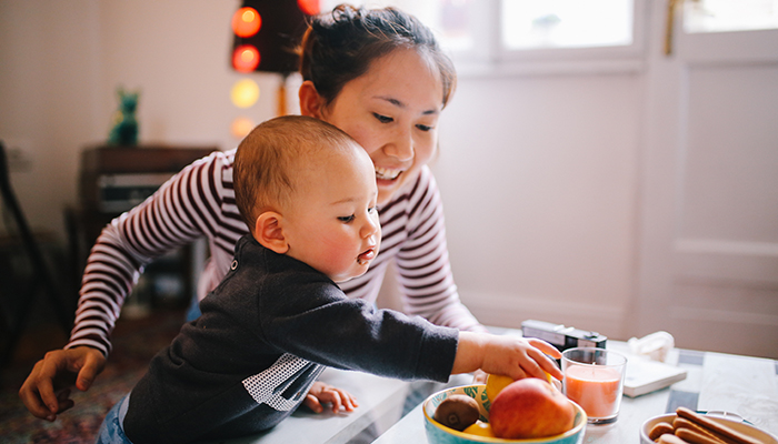 A mother and her son are enjoying playtime and snacks