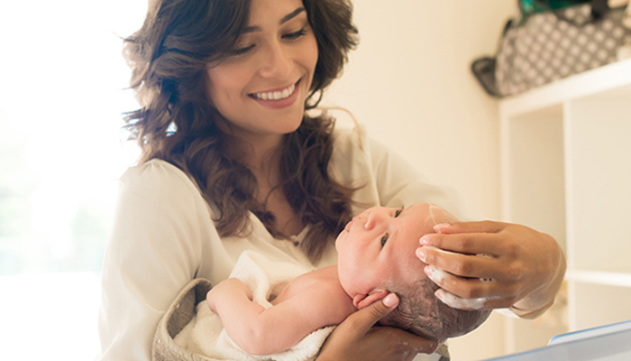 Mother bathes newborn