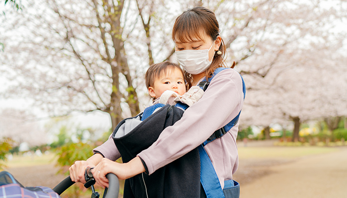 A mother is walking outside with her baby.