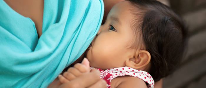 Baby girl being breastfed by her mother