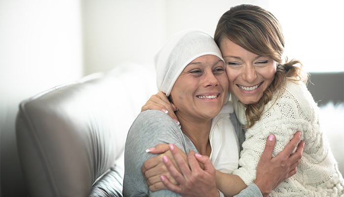 Cancer patient hugs their friend in support