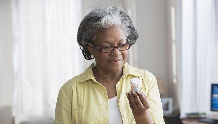 Cancer patient reading medication bottle