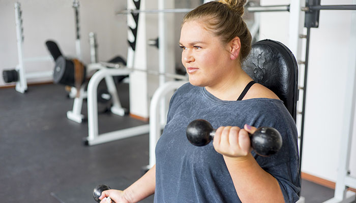 Overweight Woman Exercising in Gym