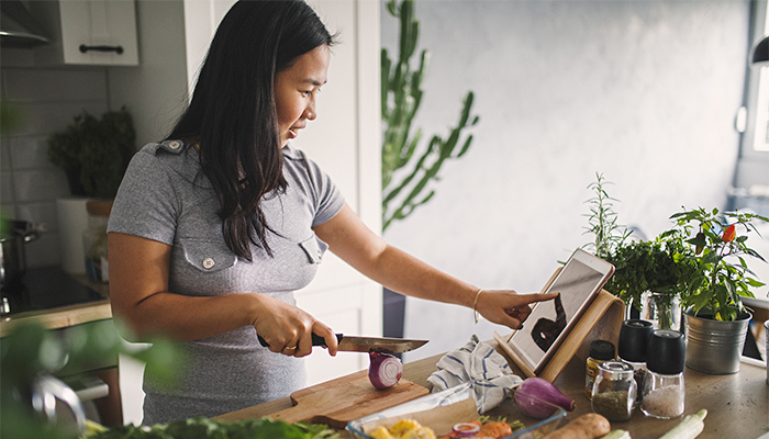 Woman chops vegetables to prepare a healthy meal