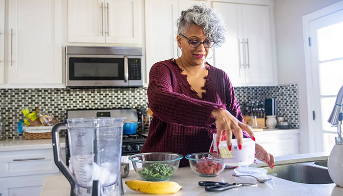 Woman preparing meal with fruits and vegetables