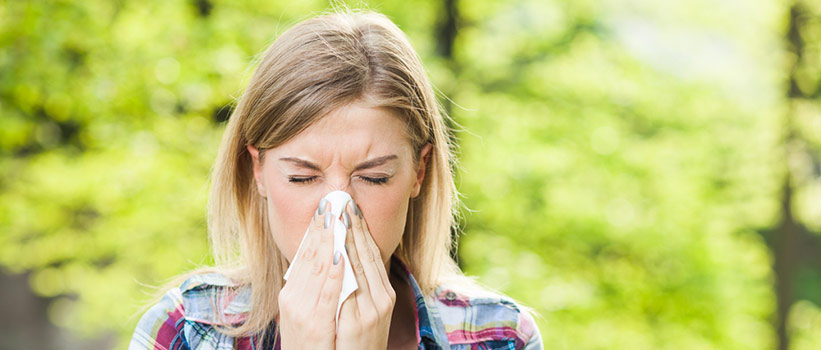 woman sneezing and blowing her nose