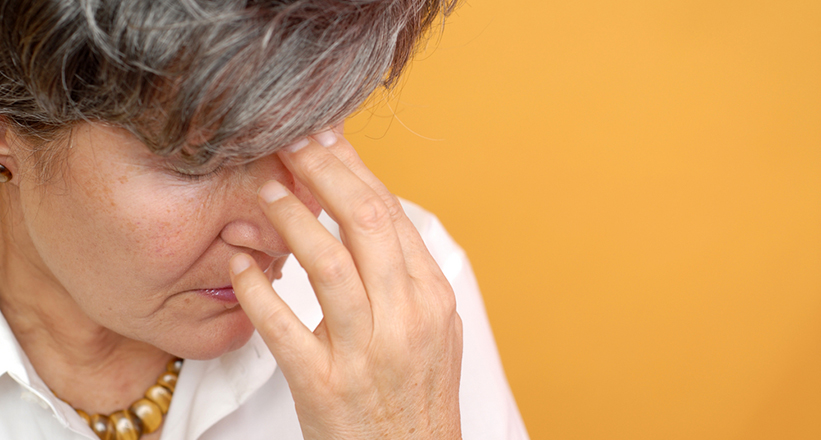 A woman is suffering from a headache.