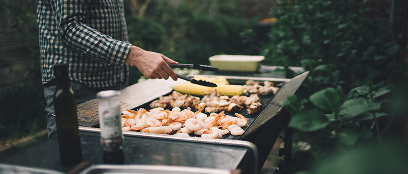 A man is cooking food on the grill.