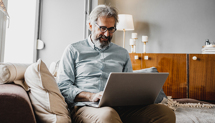 A man is attending an online event on his computer.