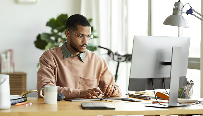 Man attends virtual class on desktop computer
