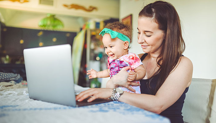 New mother with baby joining parent support group online