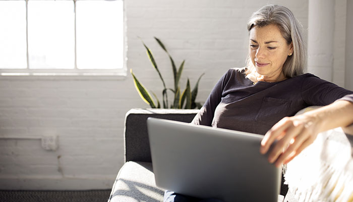 Woman attends virtual class on laptop