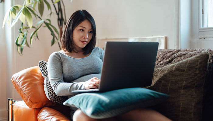 Woman attends virtual class on laptop