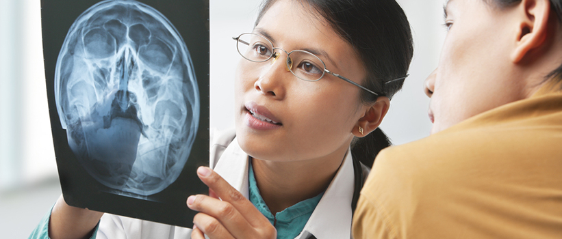 A doctor and patient review a brain scan. A doctor and patient review a brain scan.