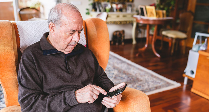 senior man using medication app on smartphone