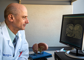 BIDMC Brain Tumor Center doctor reviews imagery of a brain BIDMC Brain Tumor Center doctor reviews imagery of a brain