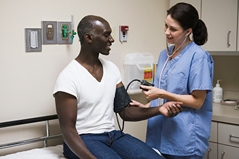 Nurse takes patient's blood pressure Female nurse takes a male patient's blood pressure