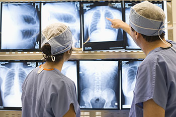 Orthopedic surgeons examining spine x-ray