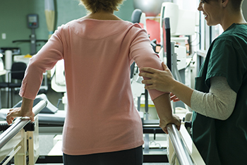 A patient receives help from a physical therapist during a session