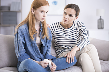 A counselor provides a young women with emotional support. A counselor provides a young women with emotional support.