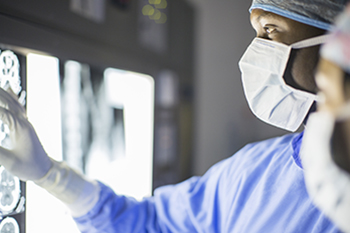 Members of the surgical oncology team are reviewing a patient's x-rays.