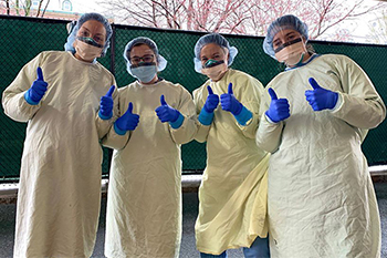 BIDMC staff members posing in PPE gowns
