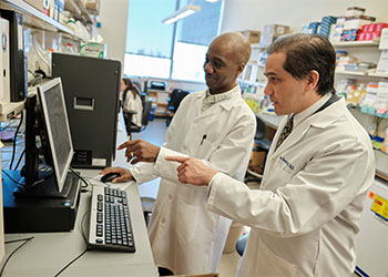 Dr. Barouch and colleague review data on computer