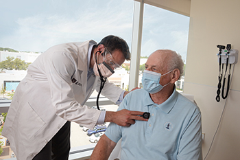 Jason Matos, MD examines a senior patient
