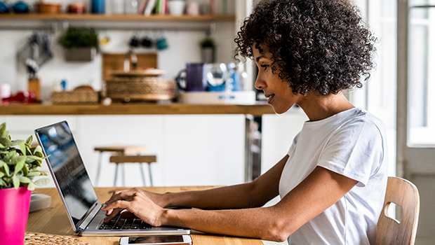 A female is attending an online event on a laptop.