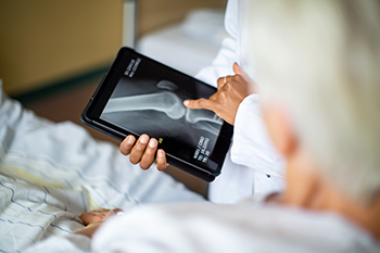 BIDMC radiologist reviews x-ray BIDMC Radiologist going over x-ray with patient