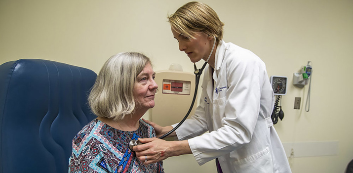 Dr. Mary Rice checking a patient's heart beat