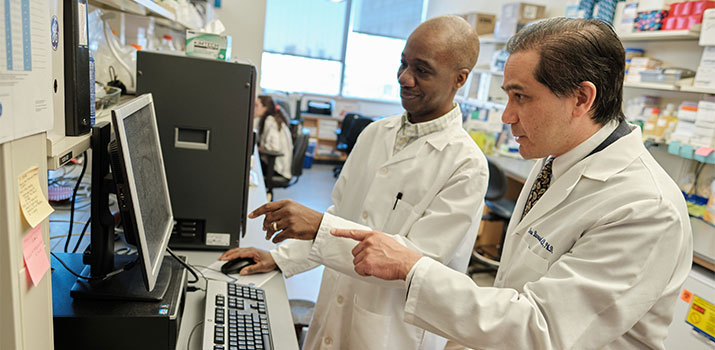 Dr. Barouch and lab member discuss data on computer